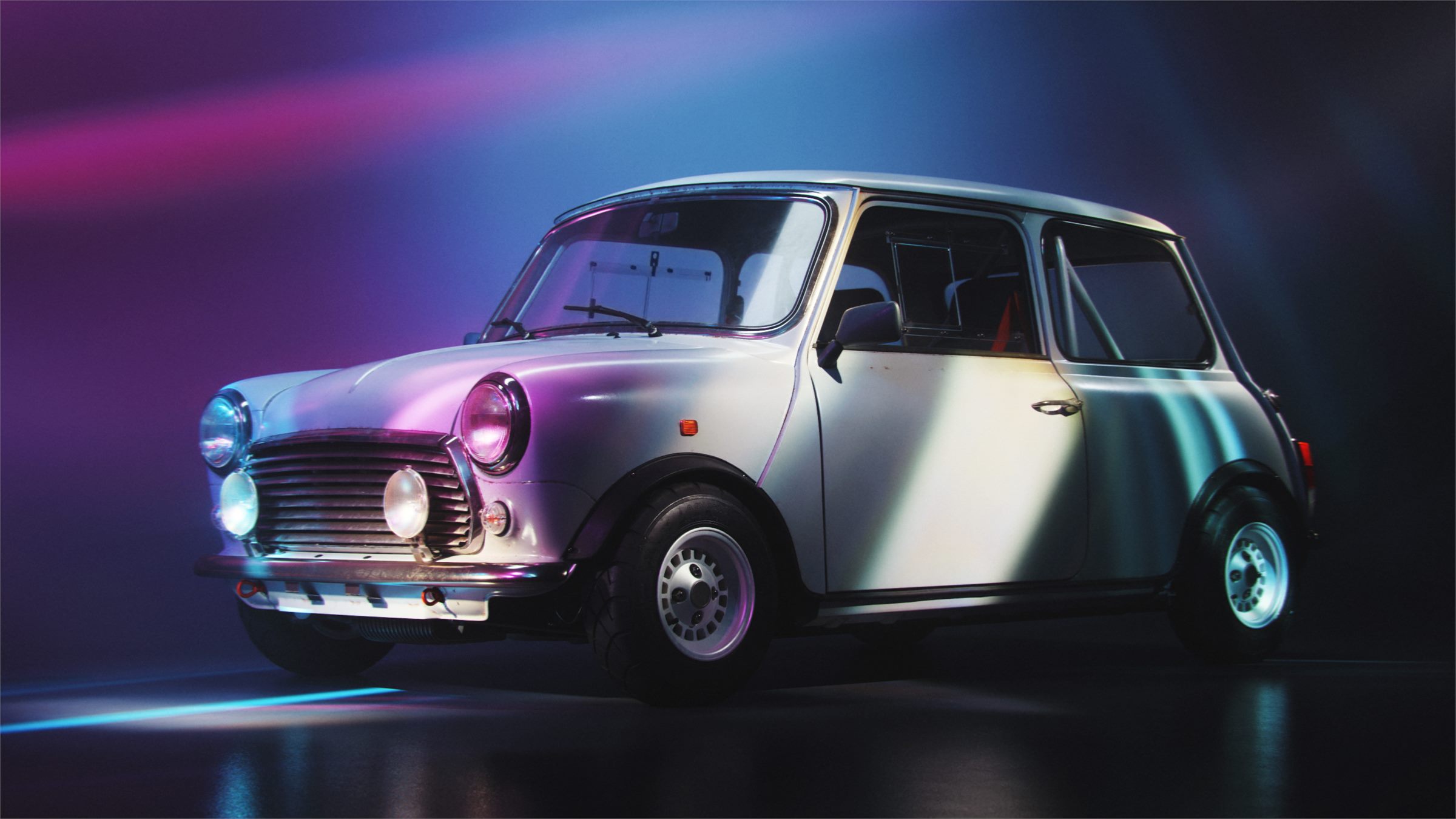Classic Mini in a dark studio lit with pink and blue light