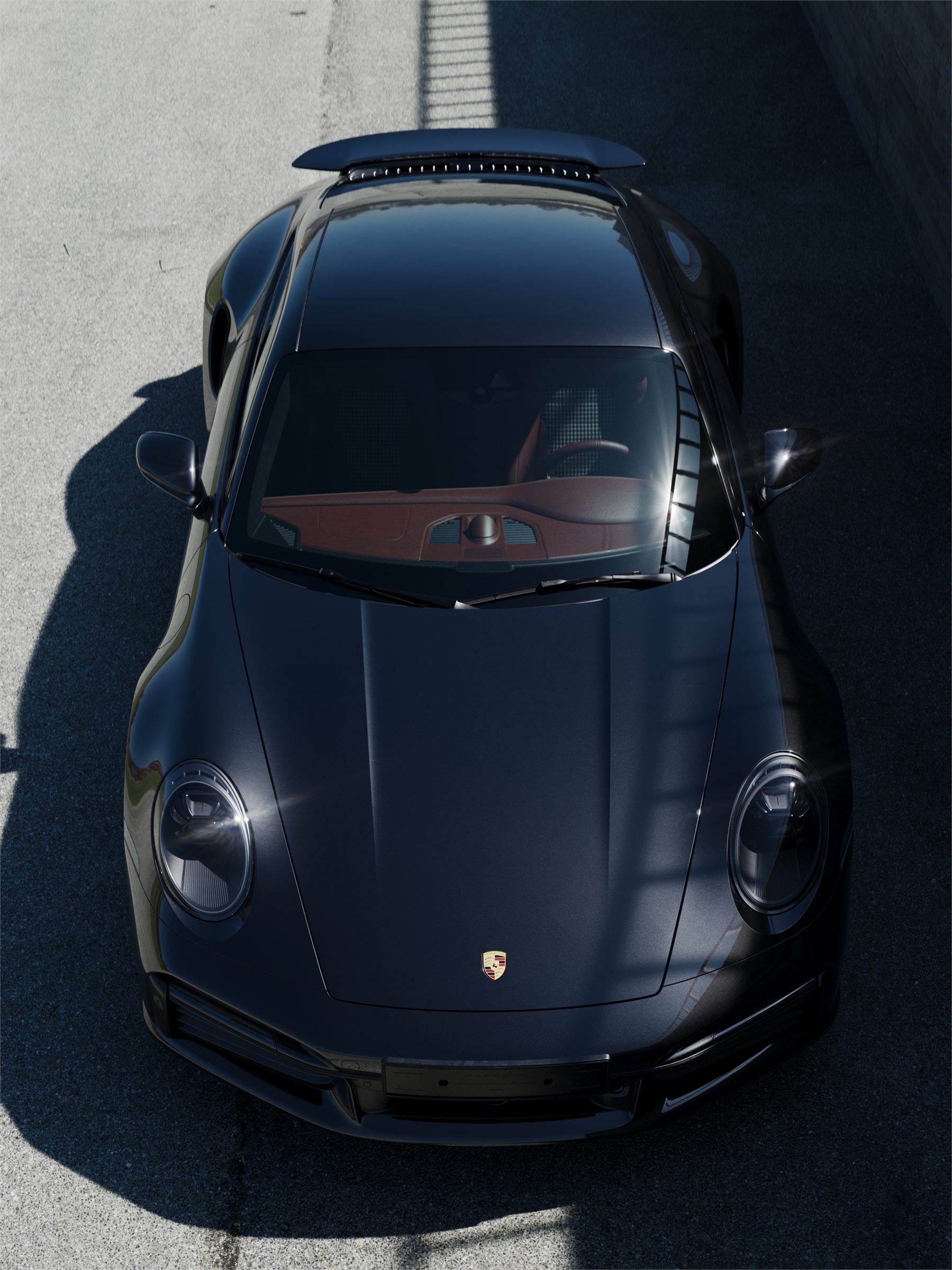 Black Porsche 911 seen from the front and above on a dark surface