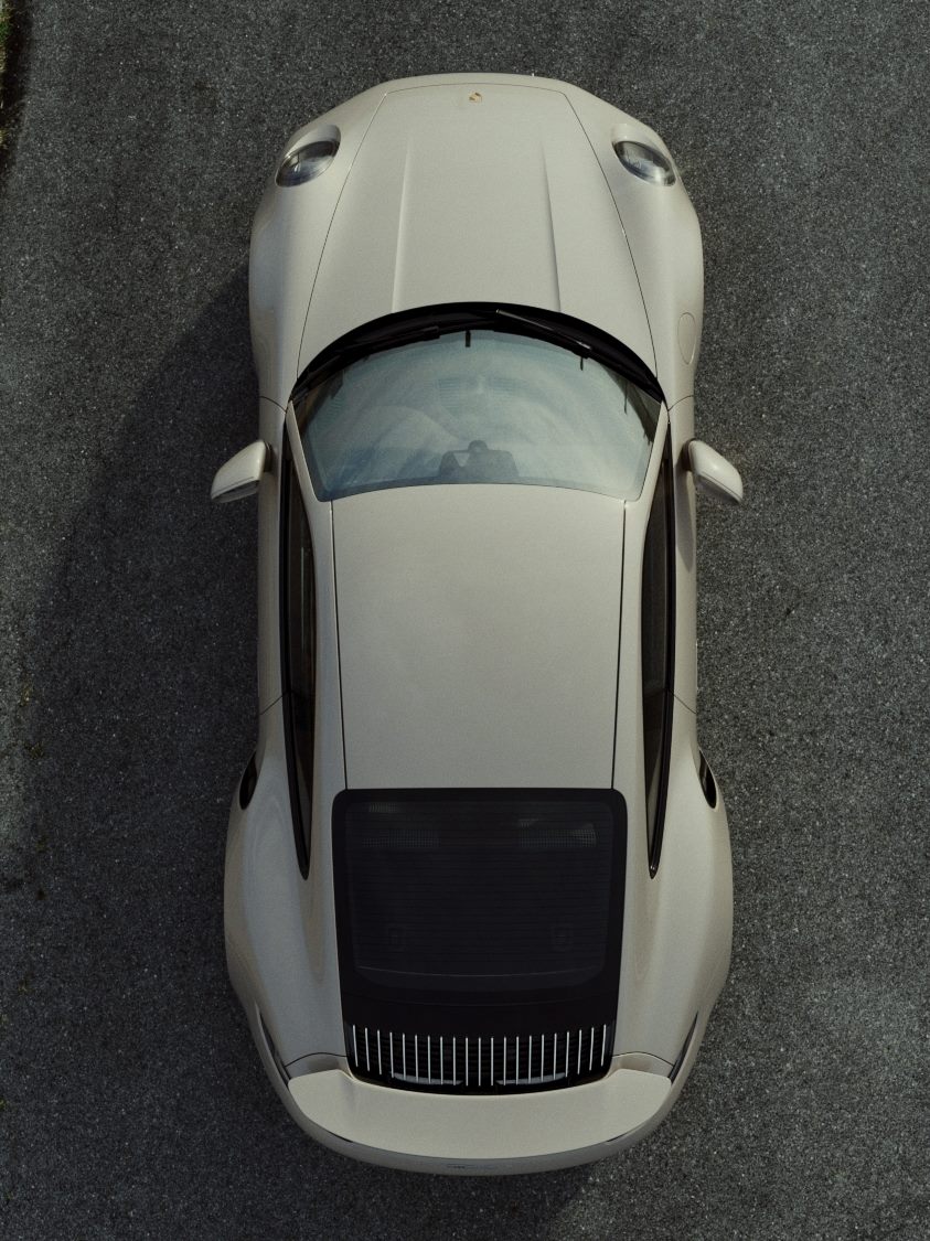 Light grey Porsche 911 seen from directly above on dark asphalt