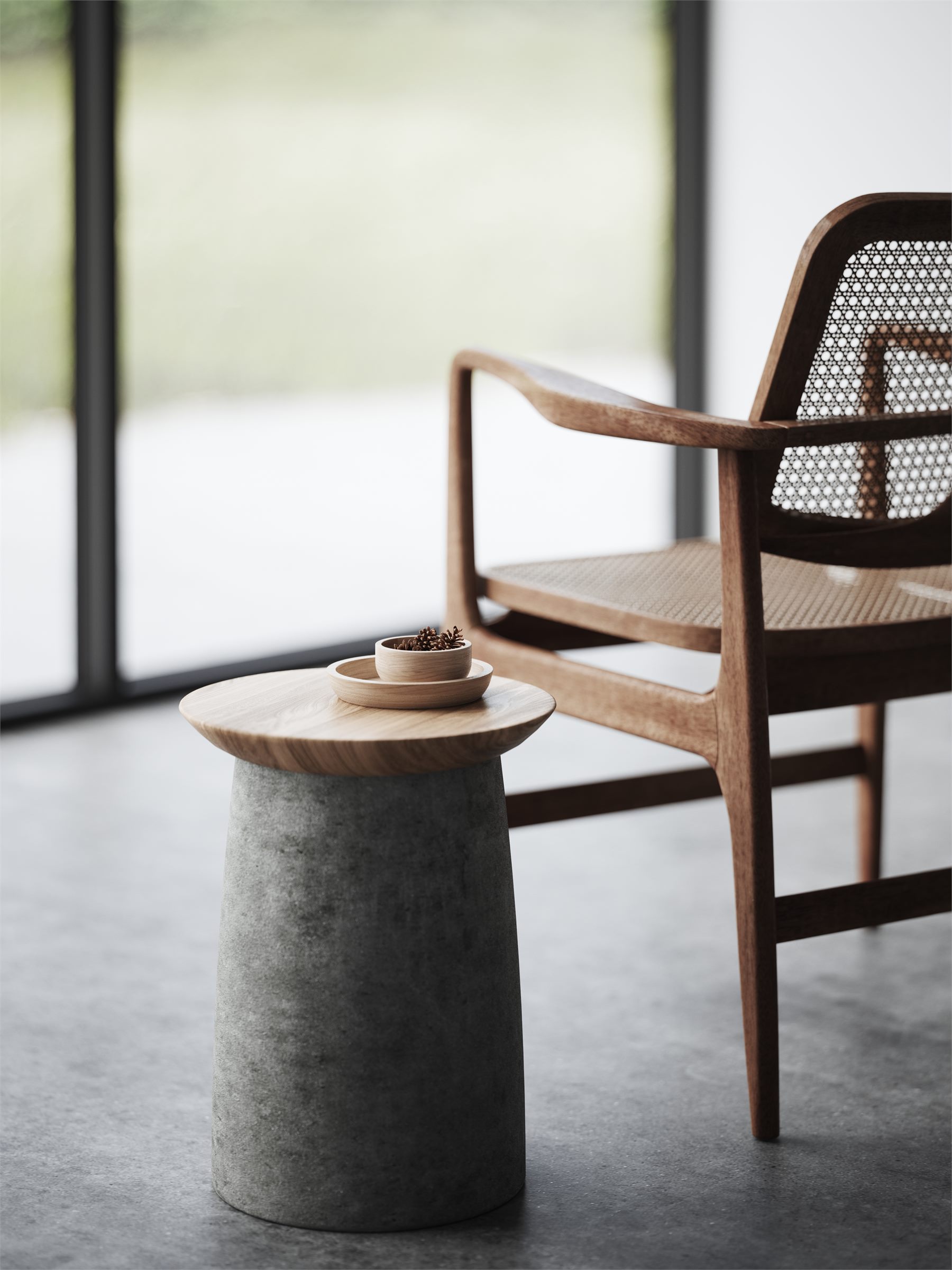 Wooden armchair with a woven back beside a round concrete side table