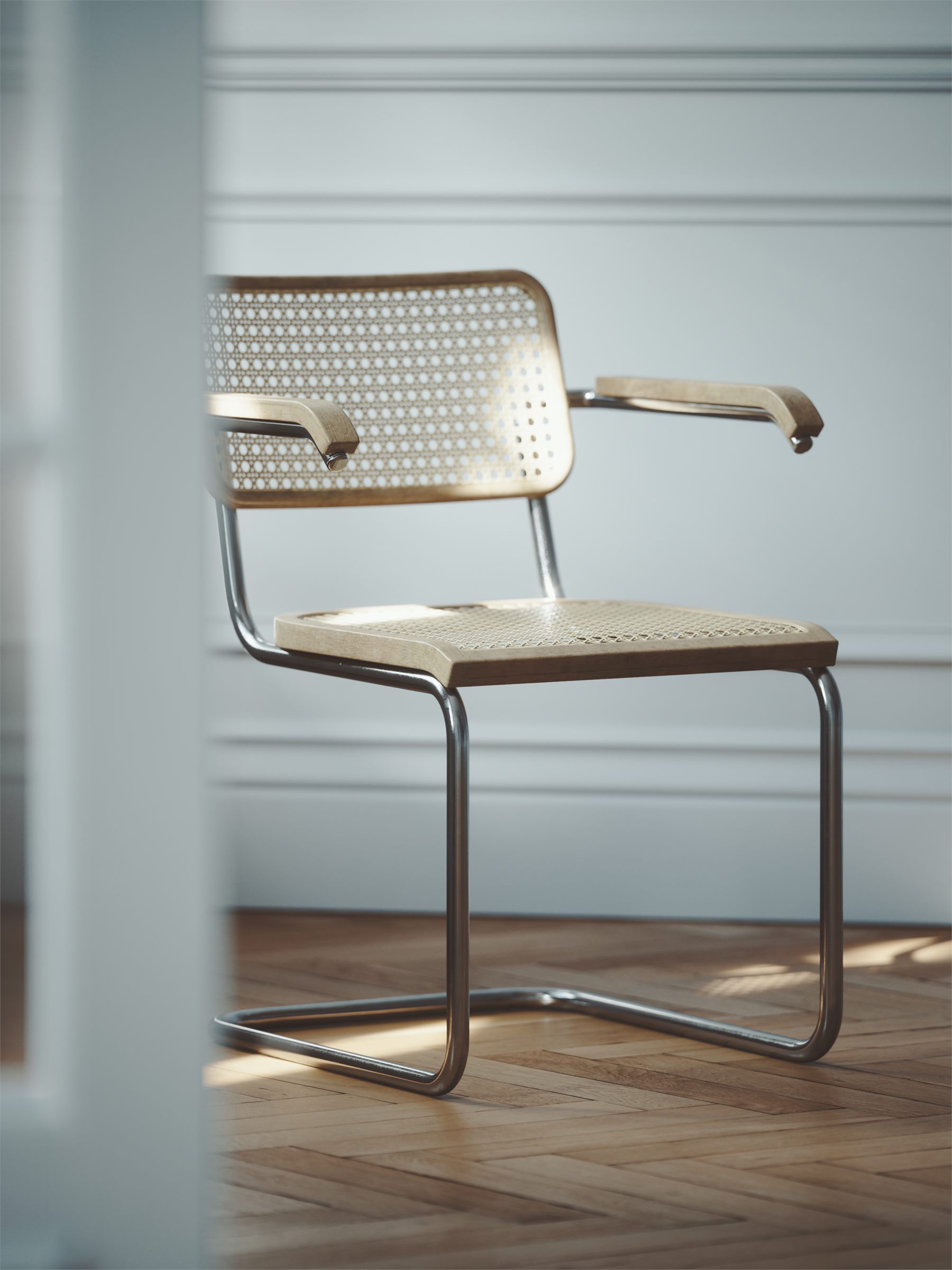 Tubular steel cantilever chair with a woven seat and back on a wooden floor