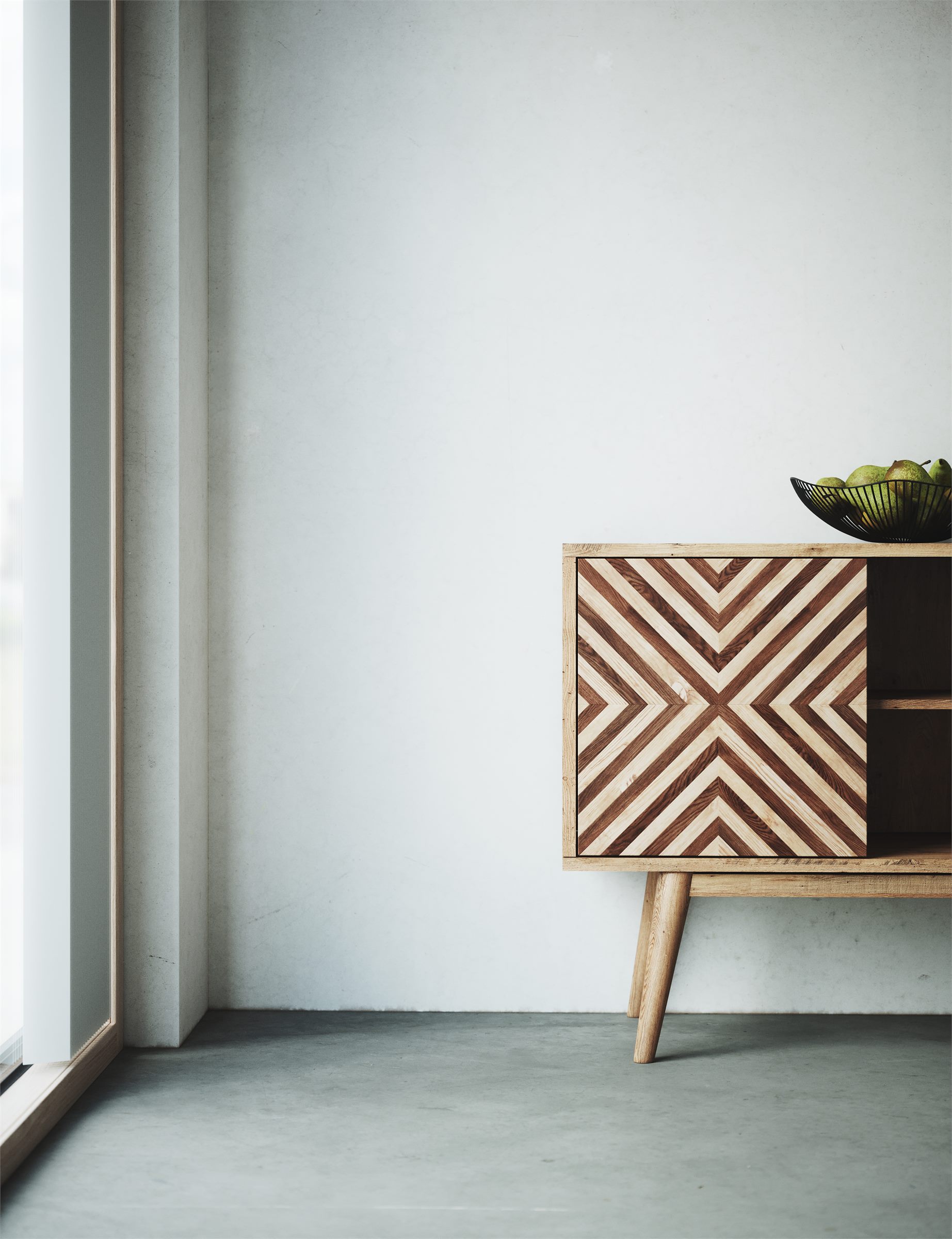 Wooden sideboard with a chevron-patterned front against a pale wall