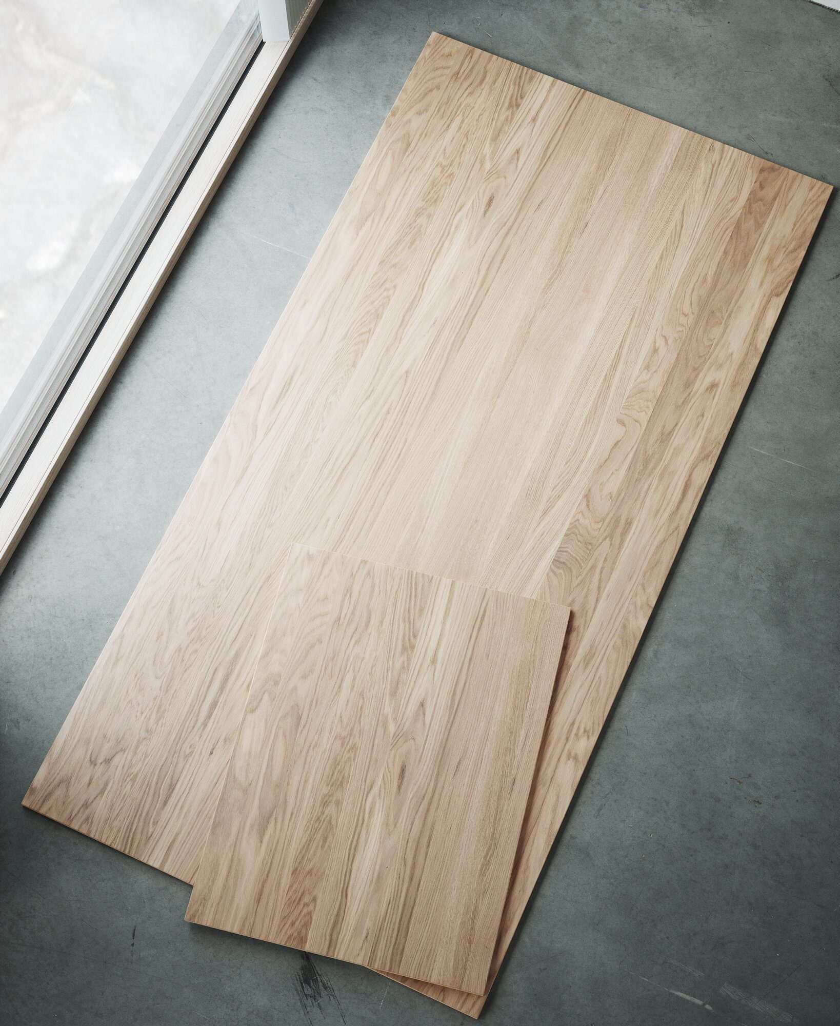 Light veneer boards leaning on a concrete floor
